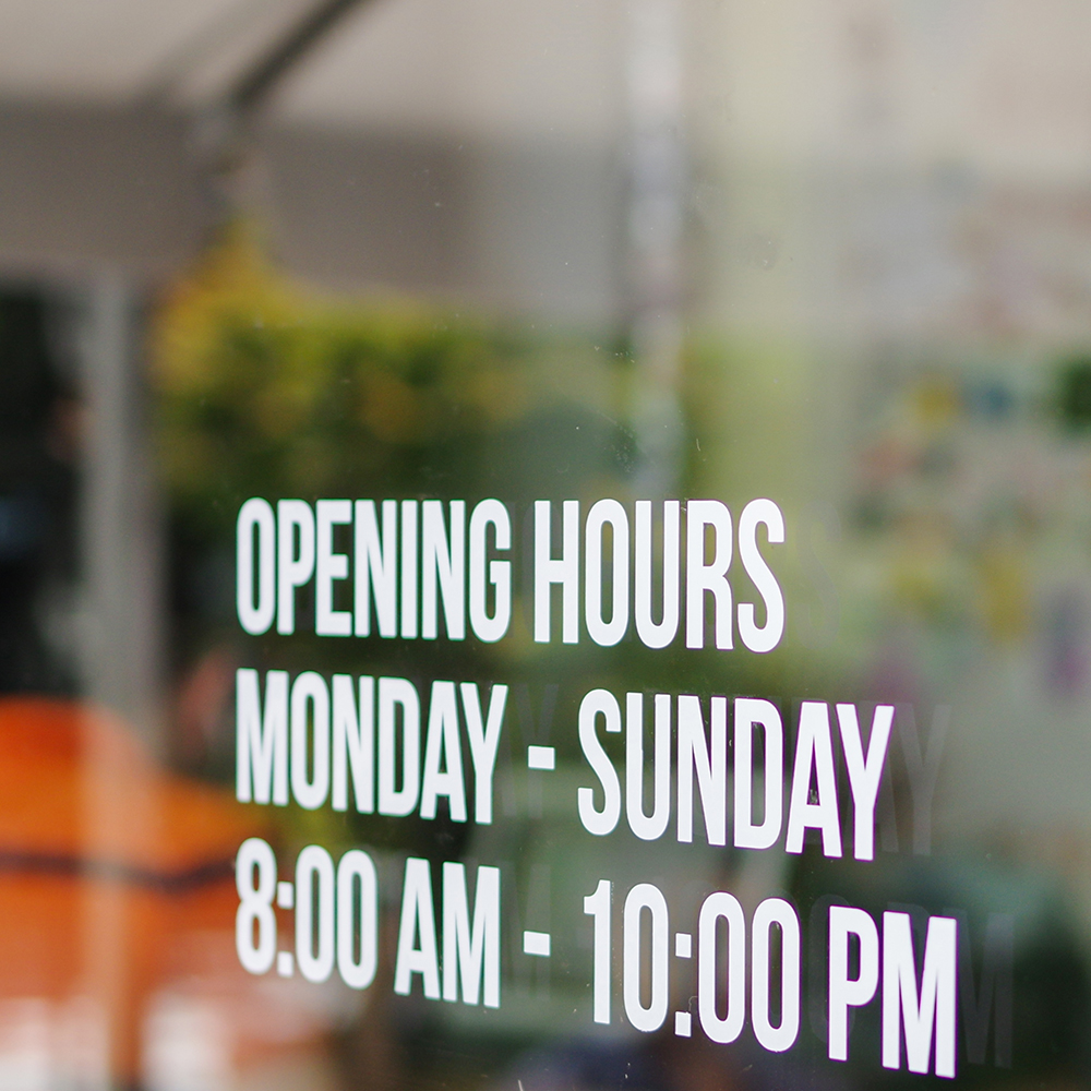Opening hour sign white decal sticker on store window glass. Mon